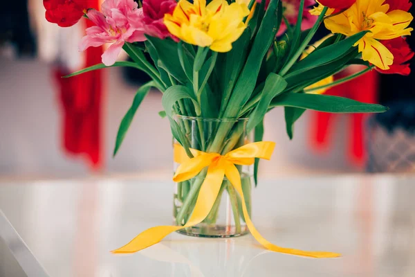 花瓶上的结蝴蝶结 水里的花 不同颜色的郁金香 家居装饰 — 图库照片