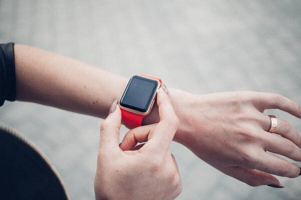 Фото женских рук, касающихся экрана, общий дизайн умных часов. Киноэффекты, размытый фон
