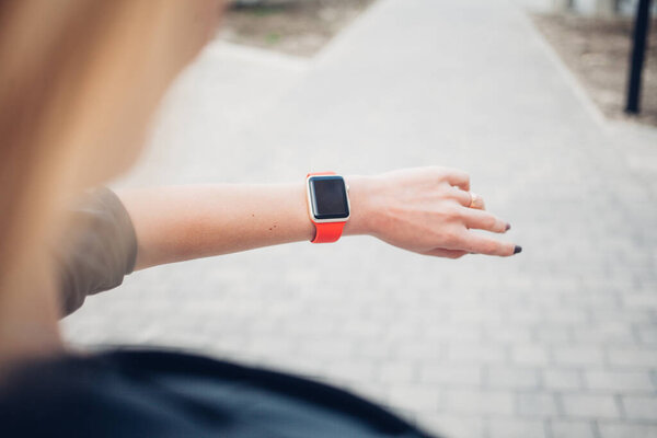 Фото женских рук, касающихся экрана, общий дизайн умных часов. Киноэффекты, размытый фон
