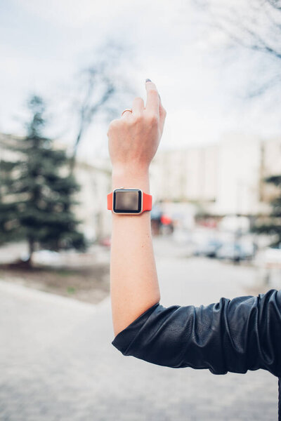 Фото женских рук, касающихся экрана, общий дизайн умных часов. Киноэффекты, размытый фон
