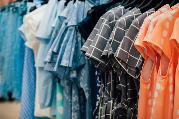 Стойка с коллекцией одежды в гримерке, женские платья крупным планом 