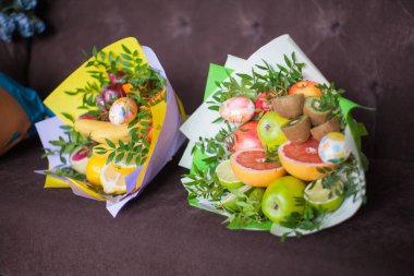 Çiçek buketleri ve kalın kağıtlara sarılmış taze narenciye meyveleri.