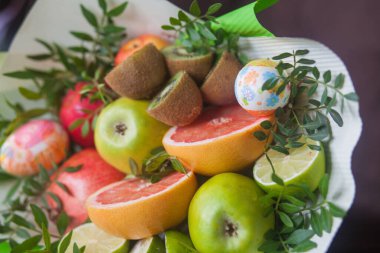 Çiçek buketi ve kalın kağıda sarılmış taze narenciye meyveleri.