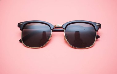 Pembe arkaplanda güneş gözlüğü, yakın plan.