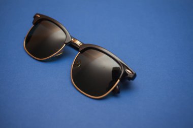 Mavi arkaplanda güneş gözlüğü, yakın plan.