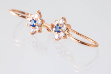 Beyaz arka planda izole edilmiş bir çift altın küpe.