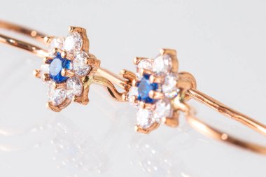 Beyaz arka planda izole edilmiş bir çift altın küpe.