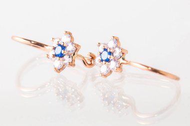 Beyaz arka planda izole edilmiş bir çift altın küpe.