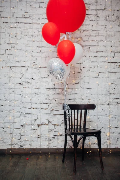 Tahta Koltuk Beyaz Tuğla Duvar Arka Planında Büyük Renkli Balonlar — Stok fotoğraf