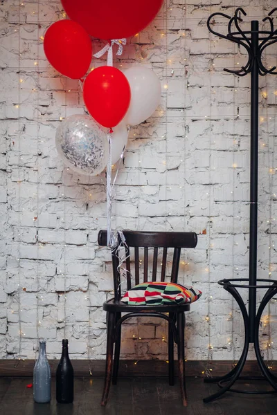 Holzsessel Und Große Bunte Luftballons Auf Weißem Backstein Hintergrund — Stockfoto