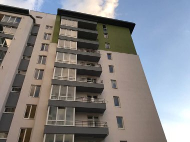 Güneşli bir günde mavi gökyüzü olan modern apartmanlar. Modern bir apartmanın cephesi