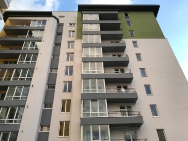 Güneşli bir günde mavi gökyüzü olan modern apartmanlar. Modern bir apartmanın cephesi