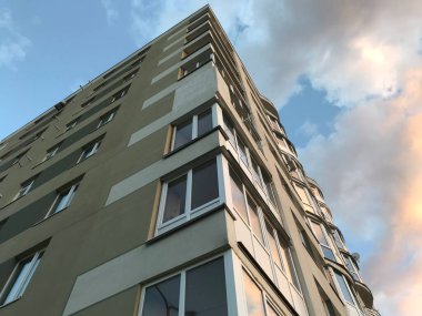 Güneşli bir günde mavi gökyüzü olan modern apartmanlar. Modern bir apartmanın cephesi