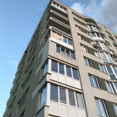 Güneşli bir günde mavi gökyüzü olan modern apartmanlar. Modern bir apartmanın cephesi