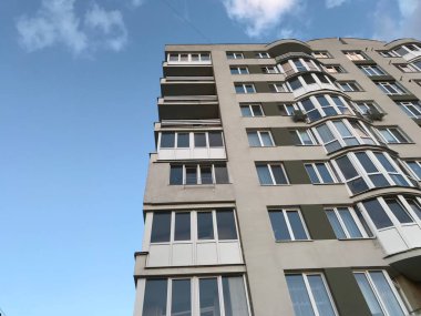 Güneşli bir günde mavi gökyüzü olan modern apartmanlar. Modern bir apartmanın cephesi
