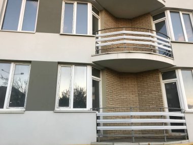 Güneşli bir günde mavi gökyüzü olan modern apartmanlar. Modern bir apartmanın cephesi