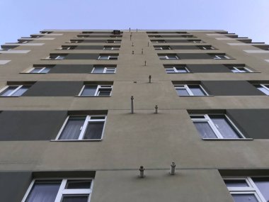 Güneşli bir günde mavi gökyüzü olan modern apartmanlar. Modern bir apartmanın cephesi