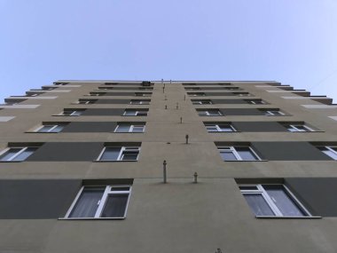 Güneşli bir günde mavi gökyüzü olan modern apartmanlar. Modern bir apartmanın cephesi