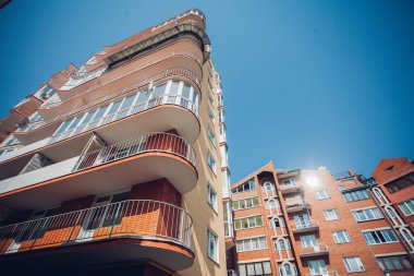 Güneşli bir günde mavi gökyüzü olan modern apartmanlar. Modern bir apartmanın cephesi