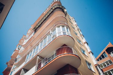 Güneşli bir günde mavi gökyüzü olan modern apartmanlar. Modern bir apartmanın cephesi