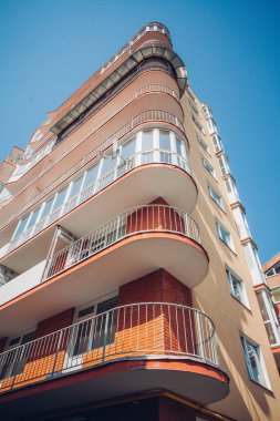 Güneşli bir günde mavi gökyüzü olan modern apartmanlar. Modern bir apartmanın cephesi