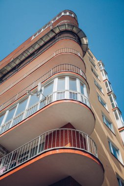 Güneşli bir günde mavi gökyüzü olan modern apartmanlar. Modern bir apartmanın cephesi