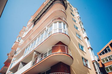 Güneşli bir günde mavi gökyüzü olan modern apartmanlar. Modern bir apartmanın cephesi