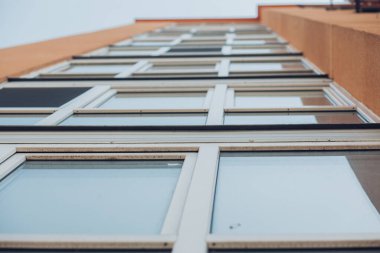 Güneşli bir günde mavi gökyüzü olan modern apartmanlar. Modern bir apartmanın cephesi