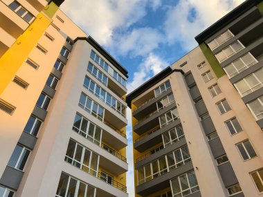 Güneşli bir günde mavi gökyüzü olan modern apartmanlar. Modern bir apartmanın cephesi