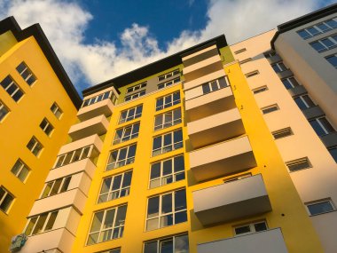 Güneşli bir günde mavi gökyüzü olan modern apartmanlar. Modern bir apartmanın cephesi