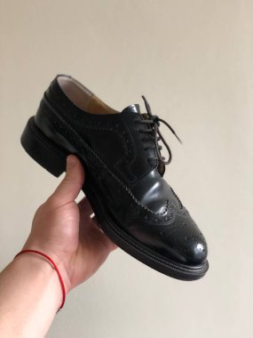 Beyaz arka planda erkek ayakkabısının el ele tutuşması. 