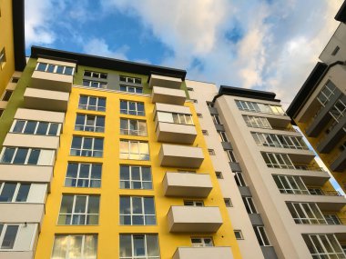 Güneşli bir günde mavi gökyüzü olan modern apartmanlar. Modern bir apartmanın cephesi