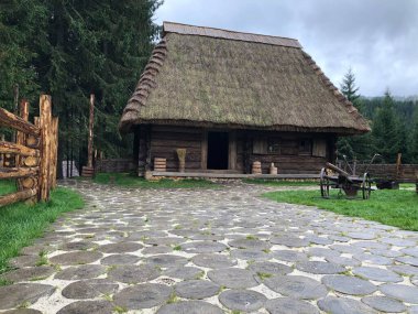 Doğal yuvarlak ahşap kütüklerden yapılmış yürüme yolu olan eski bir kır evi. Ahşap döşeme