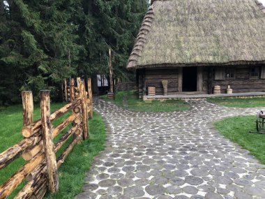 Doğal yuvarlak ahşap kütüklerden yapılmış yürüme yolu olan eski bir kır evi. Ahşap döşeme