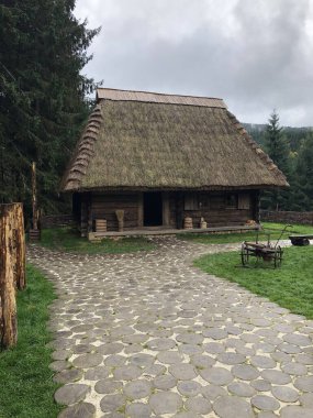 Doğal yuvarlak ahşap kütüklerden yapılmış yürüme yolu olan eski bir kır evi. Ahşap döşeme