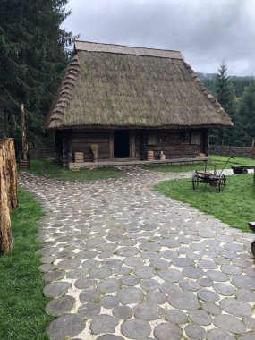 Doğal yuvarlak ahşap kütüklerden yapılmış yürüme yolu olan eski bir kır evi. Ahşap döşeme