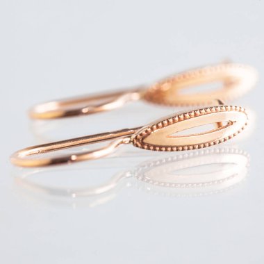 Beyaz arka planda izole edilmiş bir çift altın küpe.