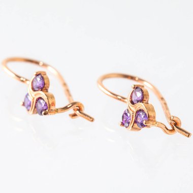 Beyaz arka planda izole edilmiş bir çift altın küpe.