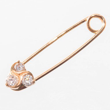 Altın çengelli iğne, yakın çekim. Mücevherler beyaz arkaplanda izole.