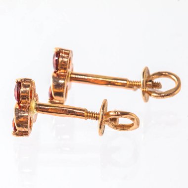 Beyaz arka planda izole edilmiş bir çift altın küpe.