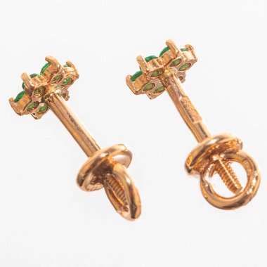 Beyaz arka planda izole edilmiş bir çift altın küpe.