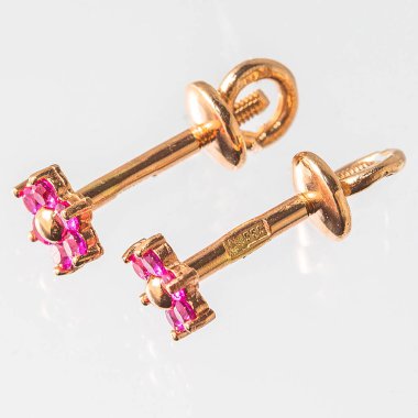 Beyaz arka planda izole edilmiş bir çift altın küpe.