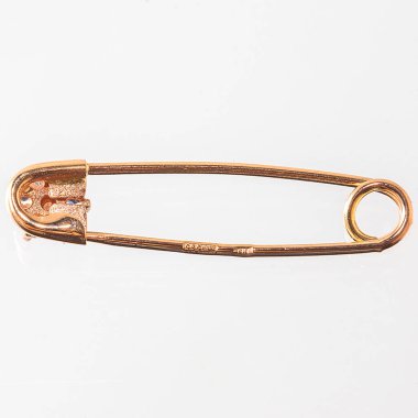 Altın çengelli iğne, yakın çekim. Mücevherler beyaz arkaplanda izole.