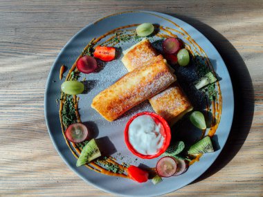 Tatlı soslu kızarmış krep ve egzotik meyveler. İnce krepli nefis kahvaltı.