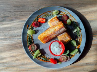 Tatlı soslu kızarmış krep ve egzotik meyveler. İnce krepli nefis kahvaltı.