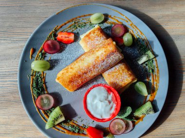 Tatlı soslu kızarmış krep ve egzotik meyveler. İnce krepli nefis kahvaltı.