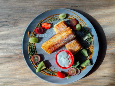 Tatlı soslu kızarmış krep ve egzotik meyveler. İnce krepli nefis kahvaltı.