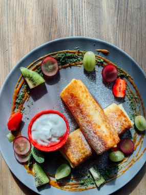 Tatlı soslu kızarmış krep ve egzotik meyveler. İnce krepli nefis kahvaltı.