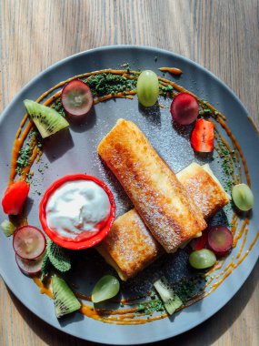 Tatlı soslu kızarmış krep ve egzotik meyveler. İnce krepli nefis kahvaltı.