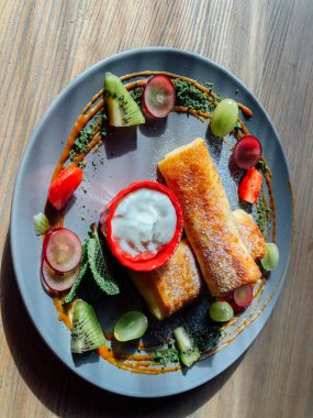 Tatlı soslu kızarmış krep ve egzotik meyveler. İnce krepli nefis kahvaltı.